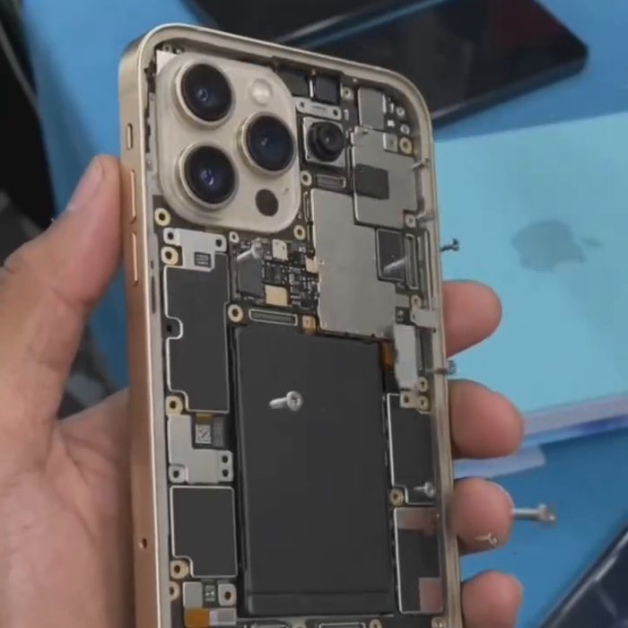 An iPhone opened down to the logic board during board-level repair at Vels Mobiles